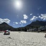 På stranden i Camps Bay med Lions head och baksidan på Table Mountain På stranden i Camps Bay med Lions head och baksidan på Table Mountain