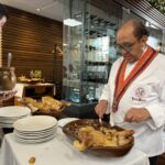 Ägaren José Maria delar grisen traditionsenligt med en tallrik, som därefter krossas på golvet Ägaren José Maria delar grisen traditionsenligt med en tallrik, som därefter krossas på golvet
