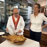 José Maria instruerar hur man delar spädgrisen med en tallrik José Maria instruerar hur man delar spädgrisen med en tallrik
